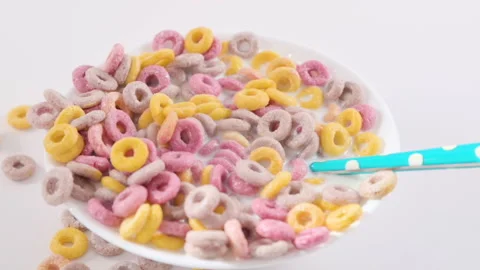 Dry breakfast in a bowl with milk. Multi-colored rings for children's breakfast 動画素材 197593405