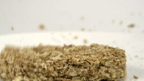 Dry breakfast cereal biscuits falling in slow motion in bowl Stock Footage 73342877