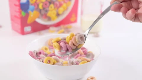 Dry breakfast Kelloggs froot loops in a bowl with milk. Multi-colored rings for Vídeo Stock 194007336