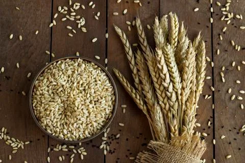 Dry a bunch of ears wheat on table with wheat bowl Stock Photos