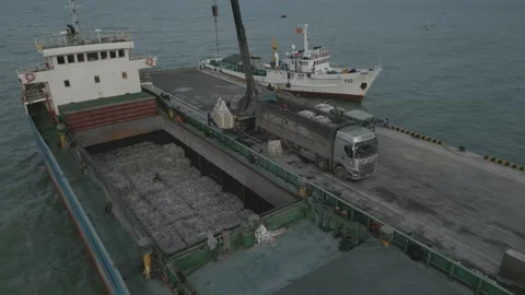 A Dry Cargo Ship With Bales Using A mobile crane Stock Footage 296596447