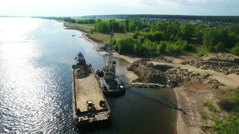 Dry cargo ship bulk carrier crane load crushed stones rock in river dock aerial Stock Footage 94378019