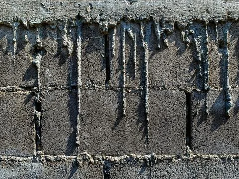 Dry cement drips on bricks wall. Mortar dripping and running down the finis.. Stock Photos