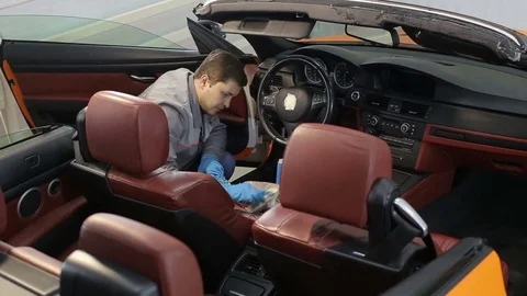 Dry cleaning of a cabriolet .Master cleans car seats. Stock Footage 76355796