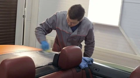 Dry cleaning of a cabriolet .Master cleans the rear of the body.Two shot Stock Footage 76356734