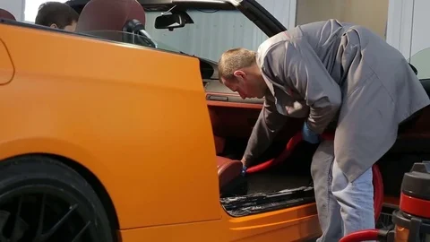 Dry cleaning of a cabriolet .The Master vacuum cleaner car interior.Two shot Stock Footage 76354551