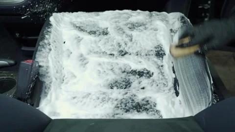 Dry cleaning of the car interior. A worker removes dirt from the seat Stock Footage 240900554
