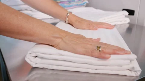 Dry cleaning. Women's hands stack white bed linen. Stock Footage 227277844
