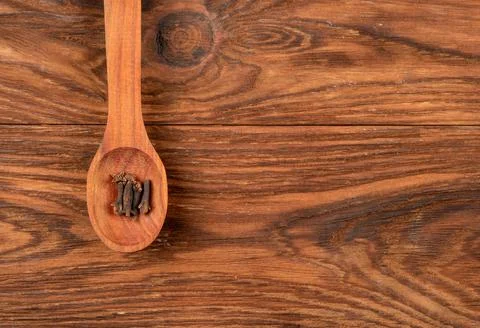 Dry cloves in spoon Stock Photos