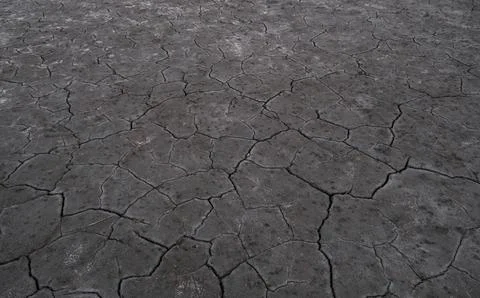 Dry cracked earth texture background representing drought, climate change and Stock Photos