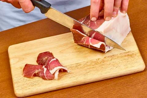 Dry cured ham thinly sliced Closeup on chef hands slices prosciutto Italian Stock Photos