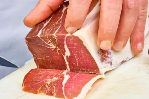 Dry cured ham thinly sliced Closeup on chef hands slices prosciutto Italian Stock Photos
