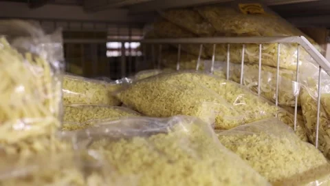 Dry curly pasta packed in clear plastic bags on a grocery store shelf Stock Footage 345978930