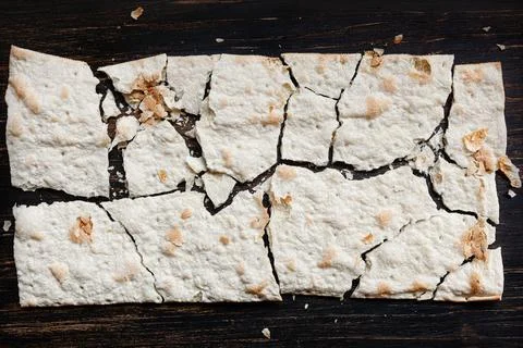 Dry flat bread broken in pieces and divided, with crumbs Foto stock