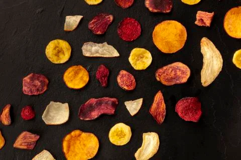 Dry fruit and vegetable chips, shot from the top on a black background with a Foto stock
