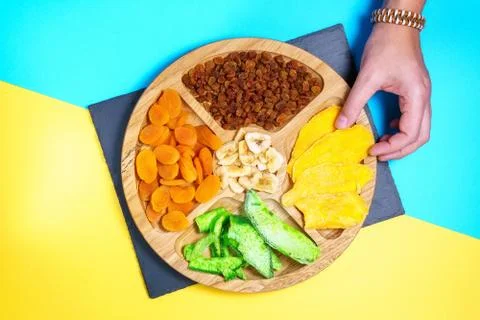 Dry fruit on a colored background, top view. mango, raisins, papaya, bananas, Stock Photos