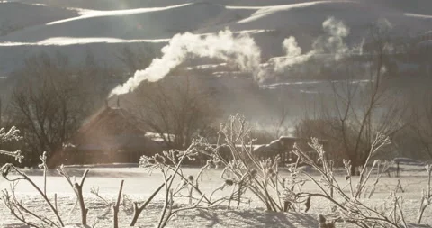 Dry grass against the background of smoke coming from chimney of a village house Stock Footage 138848545