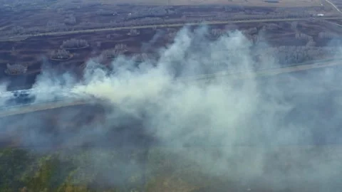 Dry grass is burning in the field below. Stock Footage 167205697