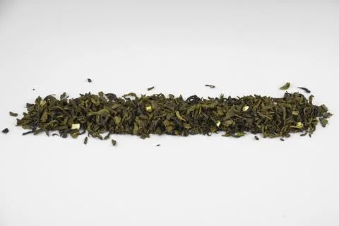 Dry green leaf tea aligned pile (line), closeup (macro) isolated, top view Foto stock