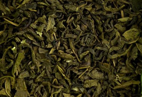 Dry green leaf tea background, closeup (macro), top view Stock Photos