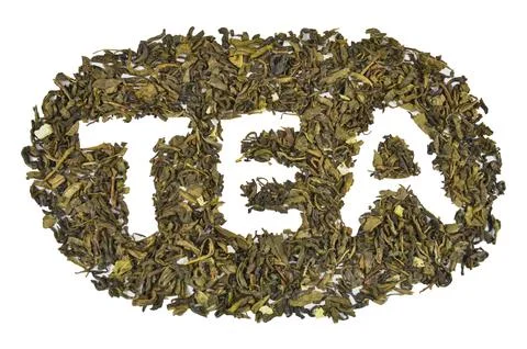 Dry green leaf tea shaped into inscription (text) "TEA", closeup (macro) Foto stock