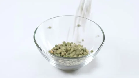 Dry green split peas falling into a glass bowl on white background Stock Footage 150329346