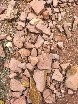 Dry ground showcases an array of red and brown stones scattered across the su Foto stock