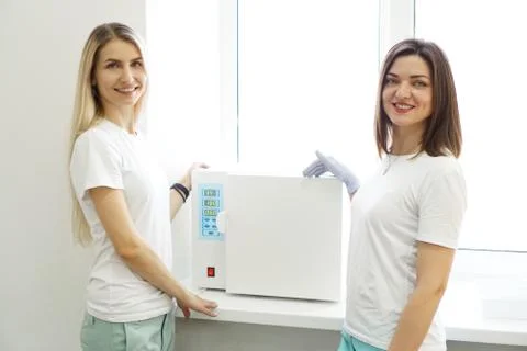 Dry heat for sterilization instruments. Two friendly masters of a beauty salon Stock Photos