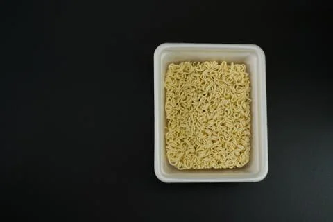 Dry instant noodles in rectangle plastic plate, top view Stock Photos