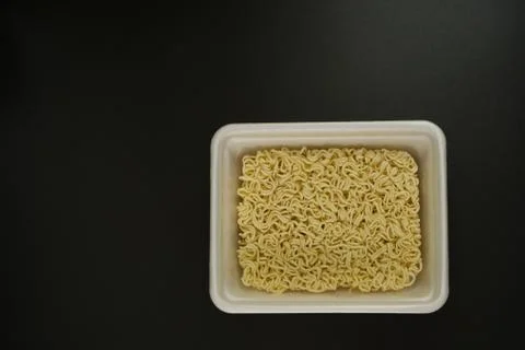 Dry instant noodles in rectangle plastic plate, top view Stock Photos