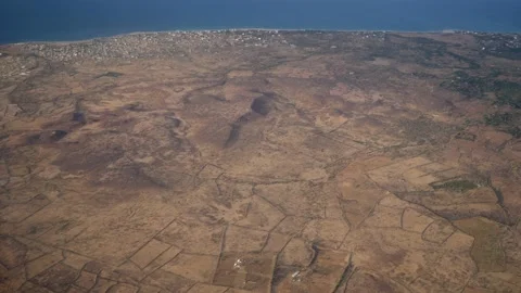 Dry land with fields along coast of Senegal, building close to the shore Stock Footage 208940747