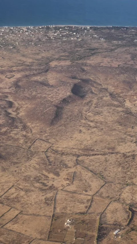 Dry land with fields along coast of Senegal, building close to the shore 스톡 동영상 230692327