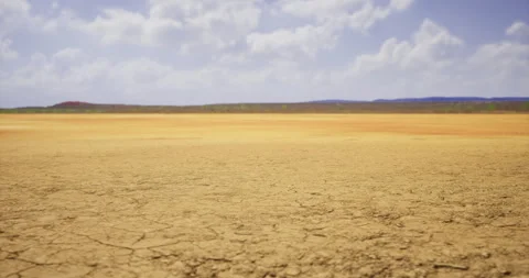 Dry landscape with cracked earth under a blue sky in midday sunshine Video stock 314959537