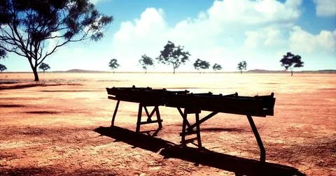 Dry landscape features an abandoned workbench under a bright sky Illustrazione stock