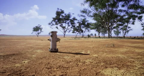 Dry landscape with a fire hydrant under a clear sky Stock Footage 313435418