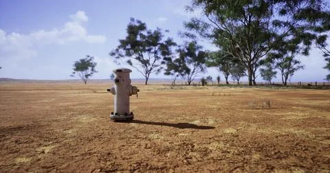 Dry landscape with a fire hydrant under a clear sky Stock Illustration