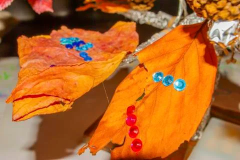 Dry leaf with plastic drops decoration close up. Stock Photos