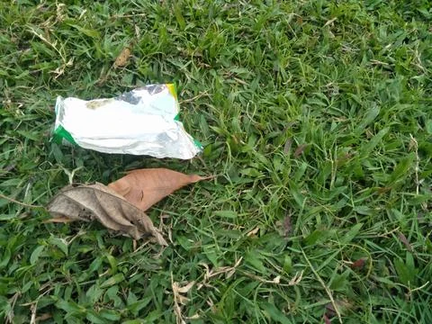 Dry leaf waste and plastic snack waste that pollutes the surrounding enviro.. Stock Photos