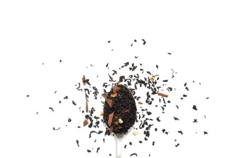 Dry leaves of black fruit tea with orange and cinnamon on a spoon. Isolate on Stock Photos