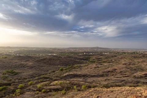 Dry mountain terrain with dramatic blue sky at evening from flat angle Foto stock