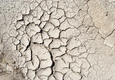 Dry mud texture of a dried riverbed due to excessive heat and drought conditi Stock Photos