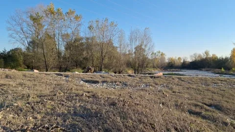 Dry Muddy River bed with Pebbles: Flat Autumn Landscape at Sunset Stock Footage 320897032