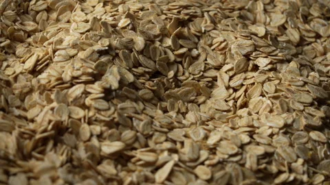 Dry oat flakes background, close up, rotation. Uncooked raw oat flakes grains Stock Footage 303001003