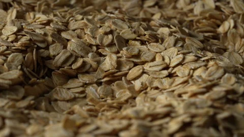 Dry oat flakes background, close up, rotation. Uncooked raw oat flakes grains Stock Footage 305625565