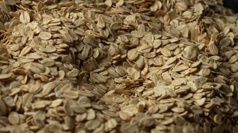 Dry oat flakes background, close up, rotation. Uncooked raw oat flakes grains Stock Footage 307637612