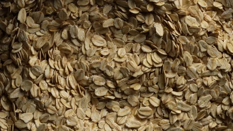 Dry oat flakes background, close up, rotation. Uncooked raw oat flakes grains Stock Footage 313473763