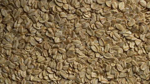 Dry oat flakes background, close up, rotation. Uncooked raw oat flakes grains Stock Footage 320598750