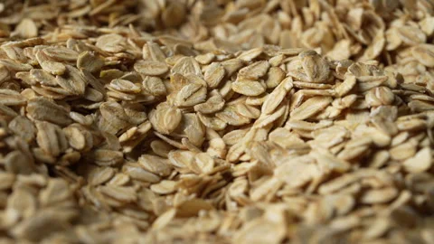 Dry oat flakes background, close up, rotation. Uncooked raw oat flakes grains Stock Footage 332421014