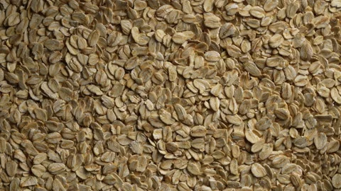 Dry oat flakes background, close up, rotation. Uncooked raw oat flakes grains Stock Footage 334046222