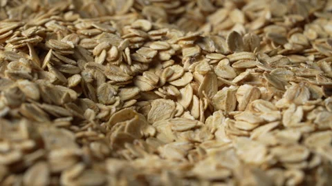 Dry oat flakes background, close up, rotation. Uncooked raw oat flakes grains Stock Footage 345708811